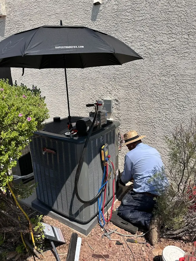 HVAC technician performing outdoor AC maintenance in Littleton